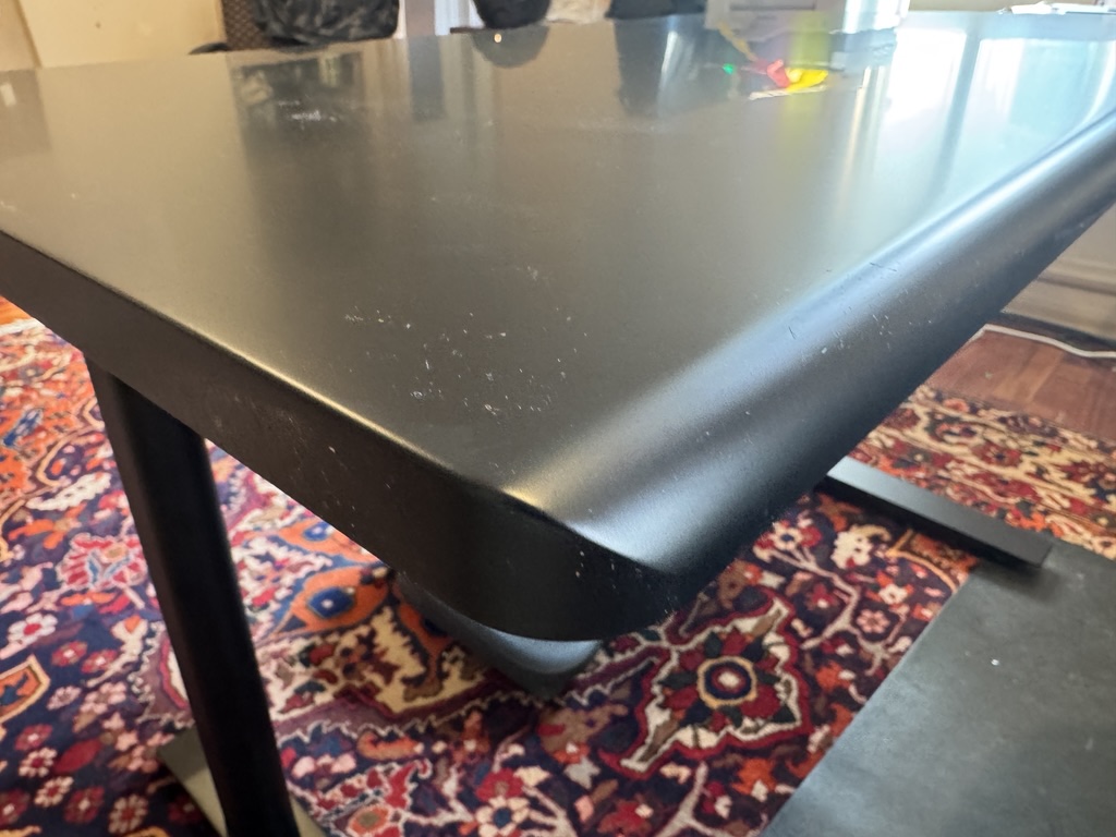 Close-up of the Autonomous Desk Pro rounded beveled tabletop edge showing quality finish